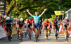 One last wave: Mark Cavendish (C) celebrates as he crosses the line to win his farewell race, the  Singapore Criterium 