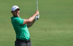 Out in front: Rory McIlroy eyes the ball after playing a shot on the first hole 