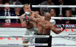 Jake Paul (left) backs Mike Tyson onto the ropes in their eight-round fight in Texas on Friday