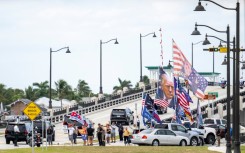 Supporters watch as the motorcade carrying US President-elect Donald Trump departs Mar-a-Lago in Palm Beach, Florida