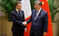 French President Emmanuel Macron (L) shakes hands with China's President Xi Jinping during a bilateral meeting on the sidelines of the G20 summit in Rio de Janeiro, Brazil