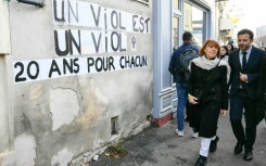 Gisele Pelicot (2nd R) walks past posters reading "Rape is rape. 20 years for every one of them" outside the Avignon courthouse