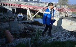 Spanish traveller Alberto Blasco Ventas walks next to the destroyed Irpin bridge in Ukraine which has become a hotspot for thrill-seeking tourists