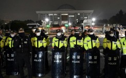 Police stand guard in front of the main gate of the National Assembly in Seoul after President Yoon Suk Yeol declared emergency martial law