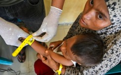 Rohingya refugees receive identity wristbands from UNHCR staff at a temporary shelter in Labuhan Haji, Indonesia