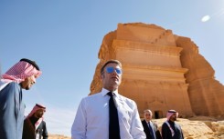 A world away from the crisis, French President Emmanuel Macron strolled through the desert sands of the Al-Ula oasis on a state visit to Saudi Arabia, marvelling at ancient landmarks