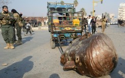 A truck pulls the head from the toppled statue of late Syrian president Hafez al-Assad through the streets of the captured Syrian city of Hama