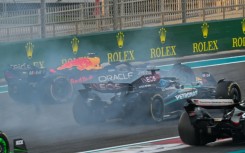 Red Bull's Max Verstappen (L) drives on after his collision with Oscar Piastri in Abu Dhabi