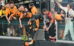 Lando Norris celebrates with the McLaren crew after winning the Abu Dhabi Grand Prix to seal the constructors' title