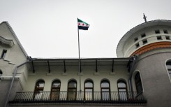 The flag of Syria's opposition waves over the country's embassy in Russia, a key ally of Assad