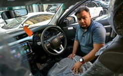 Car dealer Fahad Nazir shows AFP the inside of a Toyota Hilux pick-up truck, locally known as a 'Dala', at his lot in Karachi