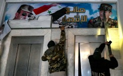 Posters of ousted president Bashar al-Assad and his father Hafez are torn down from the detention centre's upper-floor offices