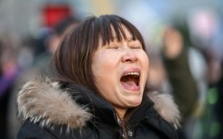 A protester calling for the ouster of South Korea President Yoon Suk Yeol reacts after the result of the second martial law impeachment vote outside the National Assembly in Seoul on December 14, 2024. South Korean lawmakers on December 14 voted to remove President Yoon Suk Yeol from office for his failed attempt to impose martial law last week.