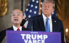 SoftBank CEO Masayoshi Son delivers remarks while US President-elect Donald Trump looks on at Mar-a-Lago in Florida on December 16, 2024