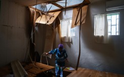 A worker cleans a room whose roof has collapsed at Mayotte's hospital