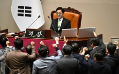 South Korea's ruling People Power Party lawmakers (bottom) argue with National Assembly Speaker Woo Won-shik (C top) during a parliamentary session