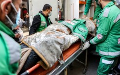 Palestine Red Crescent paramedics at Al-Ahli Arab Hospital in Gaza City move the body of their colleague Mahmud al-Muhadad, after Israeli air strikes