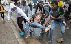 People rallied around a man shot during clashes with riot police in Maputo as large crowds turned out to welcome the opposition leader home