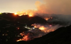 Flames and smoke from the Palisades Fire engulf parts of the community of Topanga, California