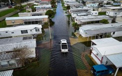 An aerial view shows a truck driving through a flooded street in the aftermath of Hurricane Milton in South Daytona, Florida