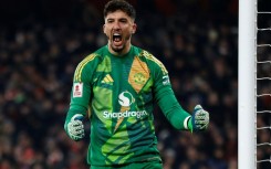 Manchester United goalkeeper Altay Bayindir celebrates after saving Kai Havertz's penalty